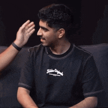 a man wearing a shirt that says hidden originals