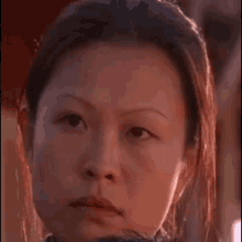 a close up of a woman 's face with a beard and a serious look on her face .