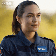 a woman is wearing a blue uniform with a patch that says medic on it
