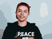 a man wearing a black shirt that says peace on it