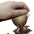 a person 's hand is reaching into a small cup