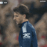 a close up of a soccer player wearing a blue shirt that says dxc technology