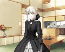 a woman in a black dress stands in a kitchen