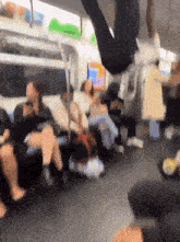 a blurry picture of people sitting on a train with a sign that says ' subway ' on it