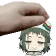 a hand is putting a cartoon character 's head on a white surface .