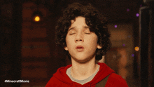 a close up of a young boy with his eyes closed