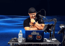 a man sitting at a desk with a laptop that says dj racer