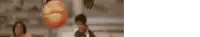 a blurry picture of a man holding a basketball in front of a woman .