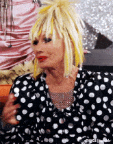 a woman wearing a black and white polka dot dress with yellow highlights