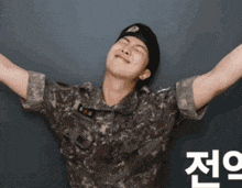 a man in a military uniform has his arms outstretched in front of a wall