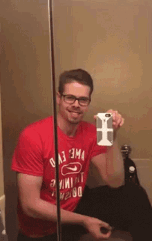 a man in a red shirt is taking a selfie