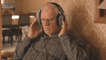 an elderly man wearing headphones with the words son of a glitch behind him