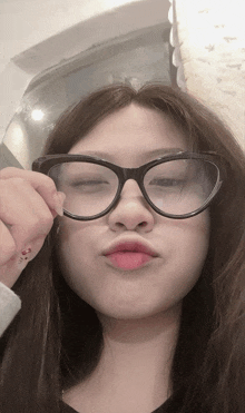 a woman wearing glasses has a tattoo on her thumb that says ' i love you '