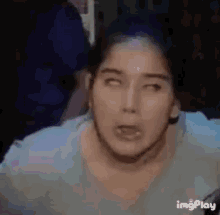 a woman is making a funny face with her eyes closed in a blurry photo .