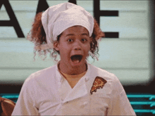 a woman in a chef 's uniform has a slice of pizza pinned to her chest