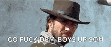 a man with a beard wearing a cowboy hat is standing in front of a wall .