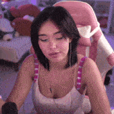 a woman sitting in a pink chair with the letters xg on the bottom