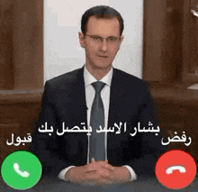 a man in a suit and tie is talking on a cell phone while sitting at a desk .