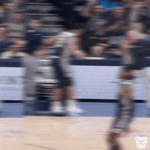 a blurry picture of a basketball game with a tiger head on the bottom right