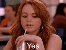 a woman is drinking a soda through a straw and the word yes is on her face .