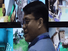 a man wearing glasses stands in front of a monitor which says ' nct ' on it