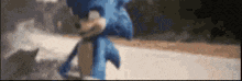 a blurry picture of a blue sonic the hedgehog walking down a road .