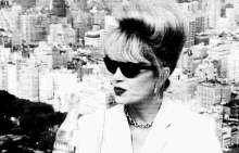 a black and white photo of a woman wearing sunglasses .