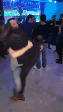 a man is carrying another man in his arms while dancing