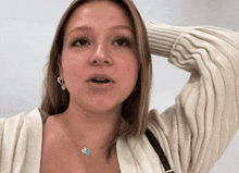 a woman wearing a necklace with a blue heart on it