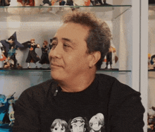 a man wearing a black t-shirt with a picture of a group of people on it