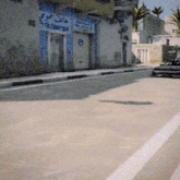 a blurry picture of a street with a building that says ' telecombox ' on it