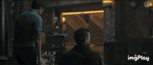 a man sitting in a dark room with the word axp on the bottom left