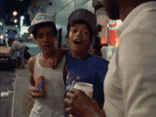a man holding a can of snickers talks to two boys