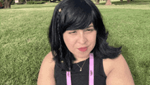 a woman wearing a black top and a purple lanyard that says ' l'oreal ' on it
