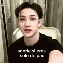 a man in a black shirt is sitting in a chair and smiling with the words sonrie si eres solo de pau written on the screen