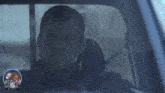 a man is sitting in a car with a sticker that says ' gruesome wiki ' on it