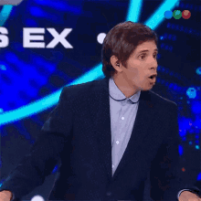 a man in a suit stands in front of a screen that says " sex "