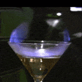 a martini glass with a purple liquid in it