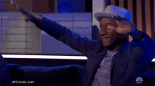 a man sitting on a couch with his arms outstretched and the words songland on the bottom right