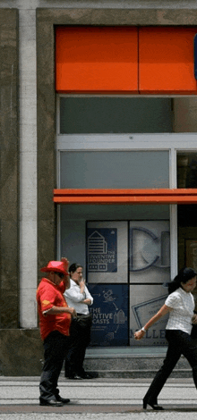 a man in a red hat stands in front of a building that says the executive housing plaza