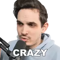 a man in a blue hoodie stands in front of a microphone with the word crazy above him