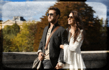 a man and a woman are holding hands while looking at something