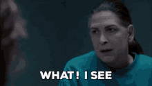 a woman in a blue shirt is looking at another woman and says what i see