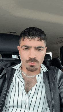 a man wearing a striped shirt and a chain around his neck