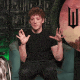 a man in a black shirt is sitting in a chair