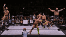 a group of wrestlers are standing in a ring with a sign that says aew