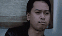 a close up of a man 's face with a slight smirk on his face
