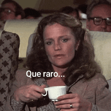 a woman is holding a cup of coffee on an airplane .