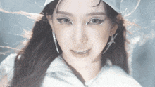 a close up of a woman 's face wearing a white hat and earrings