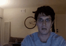 a man making a funny face in front of a bicycle